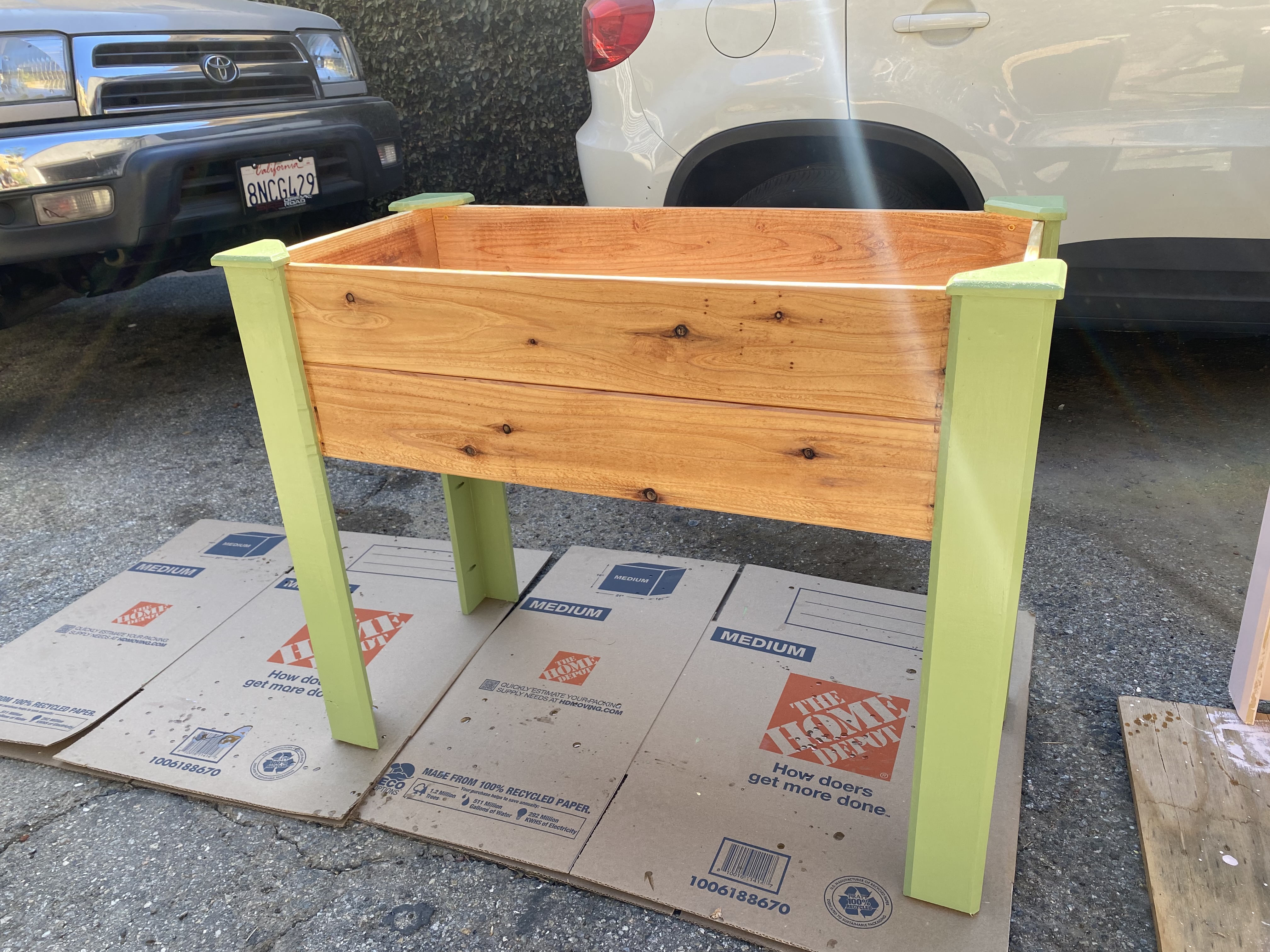 Raised planter box with green painted legs